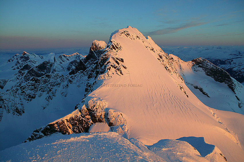 Soloppgang over Hurrungane sett fra Gjertvasstinden en maimorgen. Styggedalsryggen med Gjertvassbreen midt i mot. Storen litt bak til venstre. Til høyre i bakgrunnen Nørdre Skagastølstinden, og helt bak til venstre bl.a. Austanbotntindane, Store Ringstinden og Soleibotntindane.