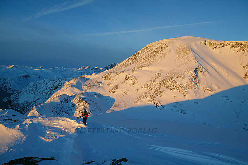 På vei ned mot Besseggen i morgenlys med en gyllenfarget Besshøe (2258 moh.) i bakgrunnen.