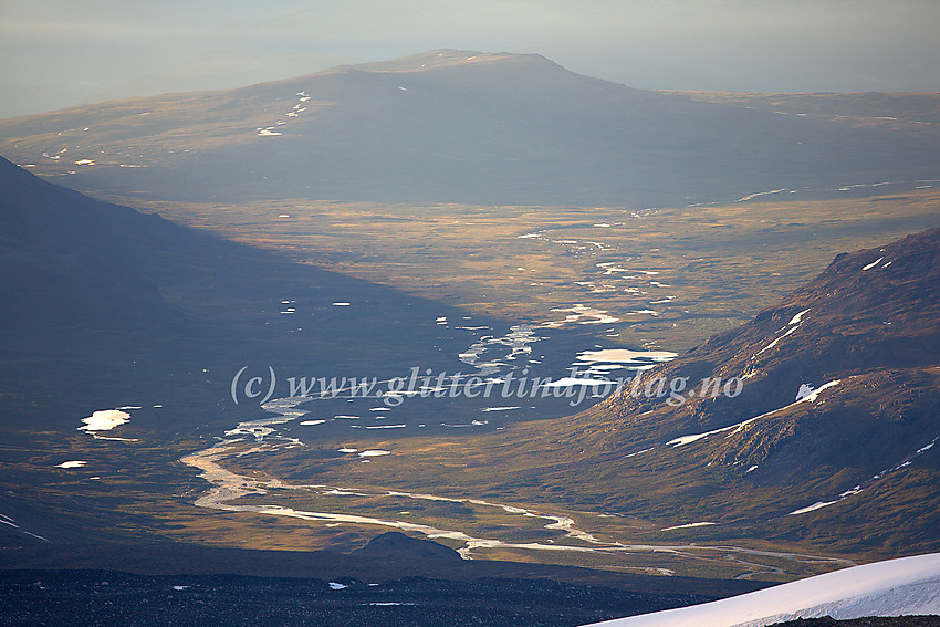 Tidlig sommermorgen med utsikt fra Glittertinden østover mot Veodalen i motlys. I bakgrunnen ruver Veofjellet (ca. 1500 moh.)