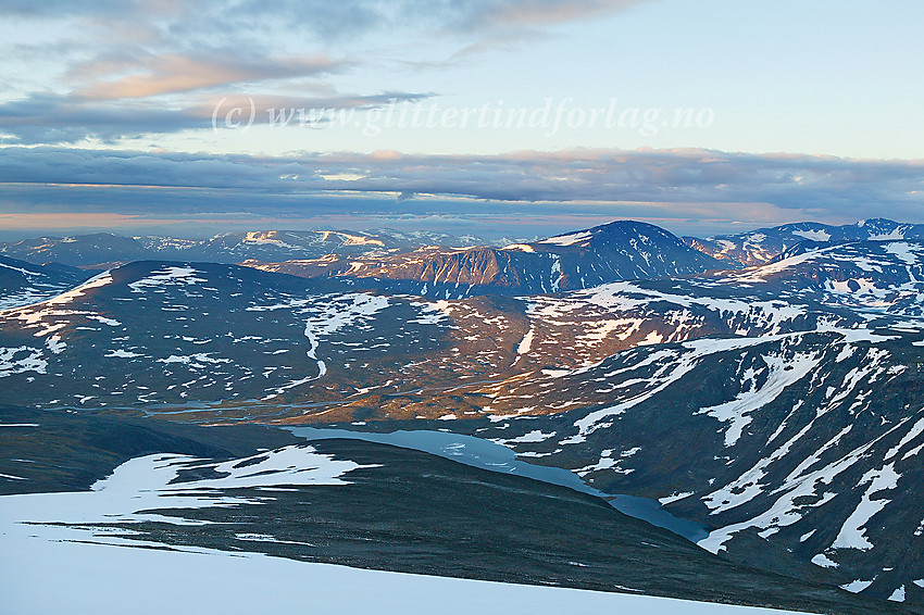 Utsikt sør til sørøstover fra Glittertinden. I forgrunnen Steinbuvatnet og Veodalen. Sentralt litt til høyre i bildet ruver Besshøe (2258 moh.)