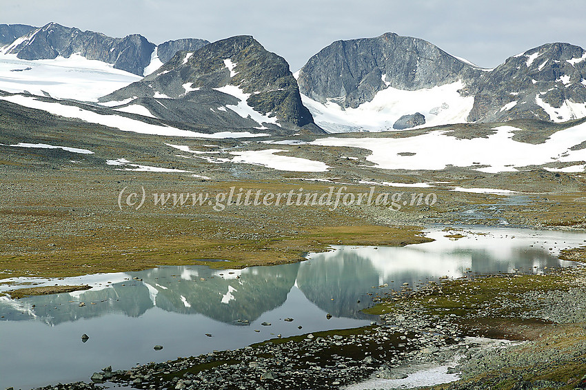 I den vakre Trollsteinkvelven med Grotbreahesten (2018 moh.) og Trollstein-Rundhøe (2170 moh.) som speiler seg i et lite brevann.