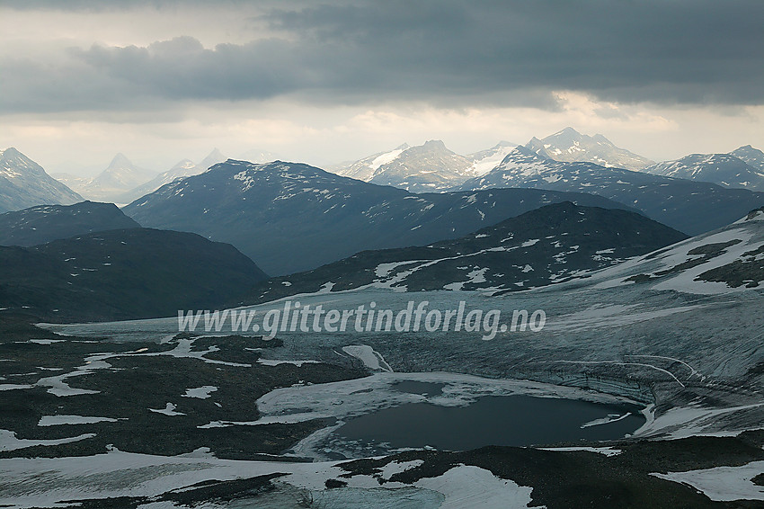 Ved nedstigningen fra Fannaråken mot Keisarpasset med utsikt innover Jotunheimen. Sagi (til venstre) og Uranostinden (til høyre) ses sentralt i bakgrunnen, mens Store Rauddalseggjes spisse profil ses bak til venstre. I forgrunnen dominerer Kongsdalsbreen med det litt spesielle brevannet, som en gang var helt omsluttet av breen.