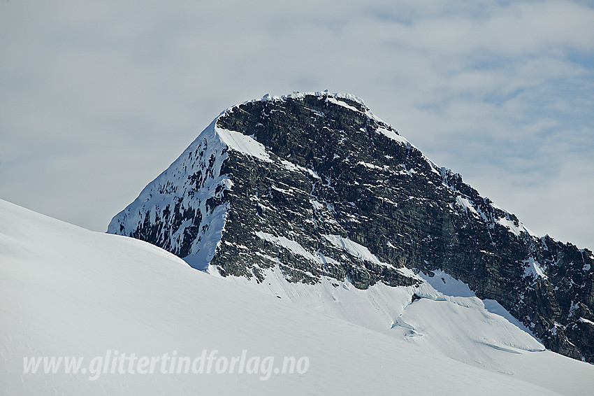 Lodalskåpa (2083 moh) med telelinse fra breen i sørvest. Legg merke til gruppen med folk på toppen, tilsynelatende helt ut mot skavlkanten.