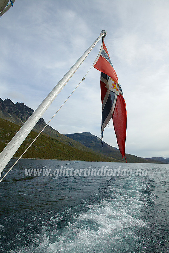 På vei vestover Bygdin med m/b Bitihorn. I bakgrunnen ses Torfinnstindane og Nørdre Kalvehølotinden.