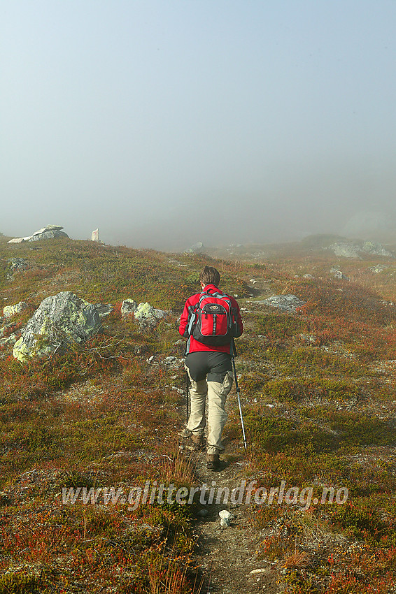 På stien fra Bygdin Høyfjellshotell til Yksendalsbu, her på vei opp mot Marabotthornet. Høsttåka ligger tjukk, men er i ferd med å lette og gløtt av sol trenger gjennom.