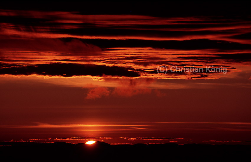 Finally the sun rises above the mountains in the very north of Glittertinden on the morning of a summer day.