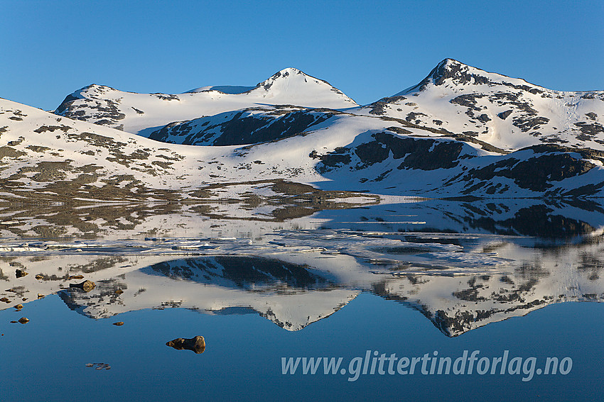 Høgvagltindane, med Midtre som den høyeste (2066 moh) i midten, speiler seg i Leirvatnet en sommerkveld.