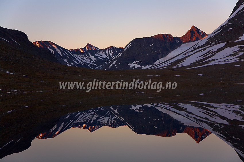 Solnedgang ved Leirvatnet mot Kyrkjeglupen med Semelholstindane (2147 moh) til høyre. Urdadalsryggen bakenfor, med Store Hellstugutinden som stikker opp bak denne igjen.