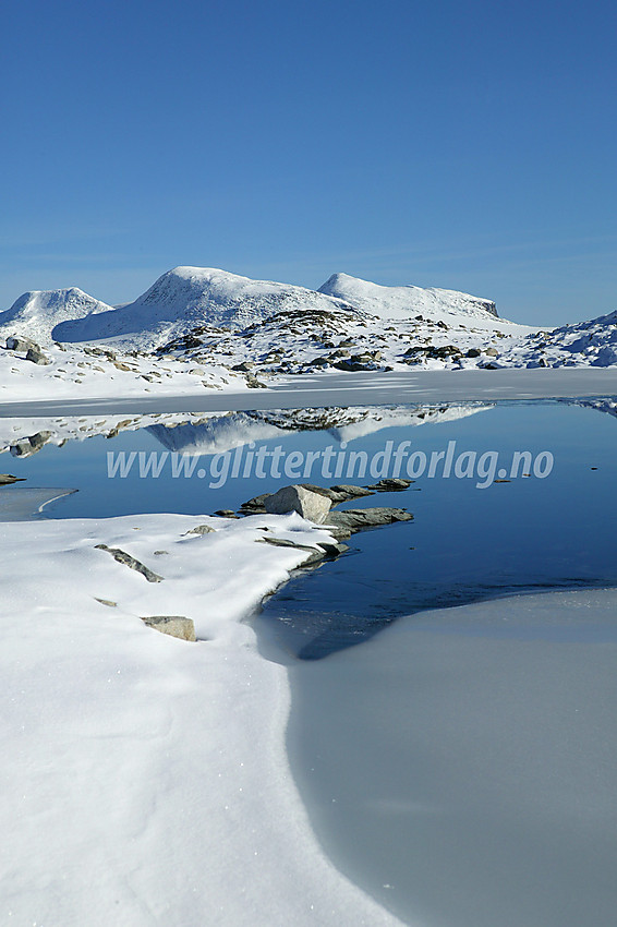 Bl.a. Vestre (2039 moh) og Midtre (2047 moh) Holåtinden speiler seg i et lite tjern sør for Steineggi. Bildet er tatt på en tur fra Nørdstedalen til Tverrådalskyrkja.