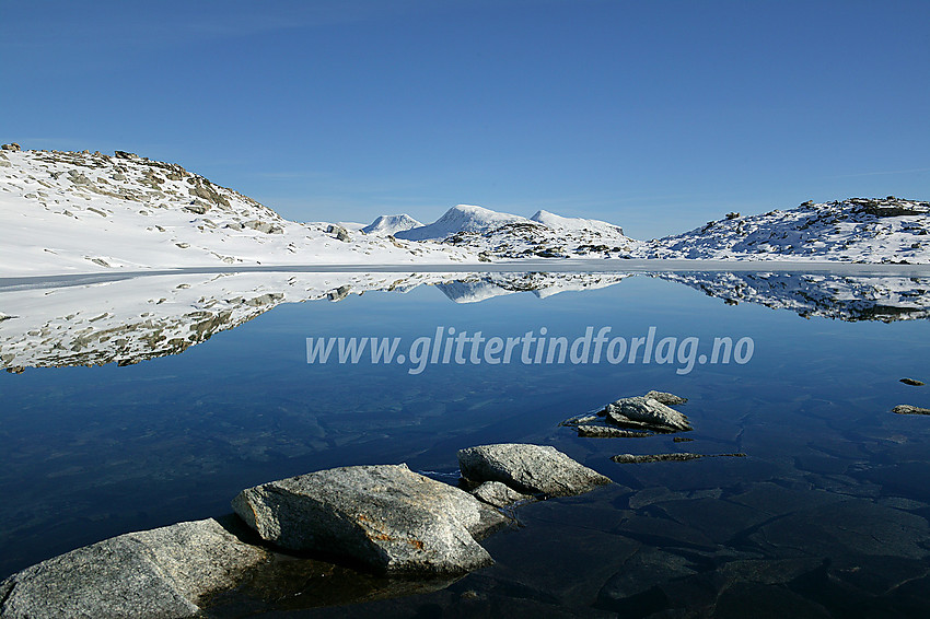 Bl.a. Vestre (2039 moh) og Midtre (2047 moh) Holåtinden speiler seg i et lite tjern sør for Steineggi. Bildet er tatt på en tur fra Nørdstedalen til Tverrådalskyrkja.