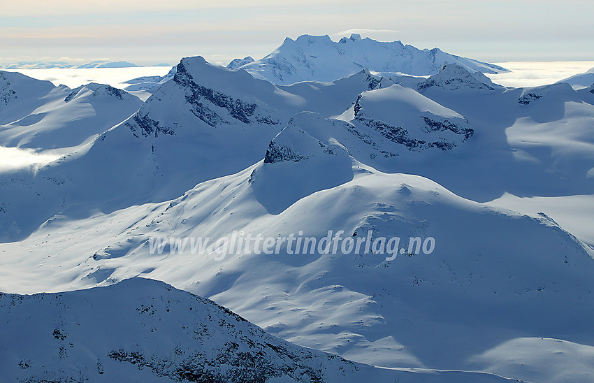 Utsikt fra Bukkehøe (2314 moh) sørvestover mot Geite (2002 moh), Storebjørn (2222 moh) og andre Smørstabbtinder, med Hurrungane i bakgrunnen.