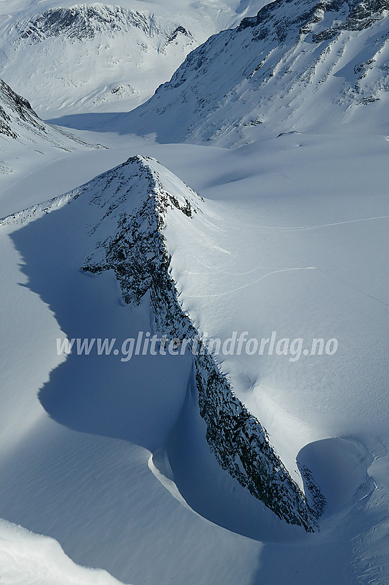 Utsikt fra Bukkehøe (2314 moh) nedover mot Lindbergtinden (2120 moh), som deler Nørdre Illåbrean (til venstre) og Tverråbrean (til høyre).