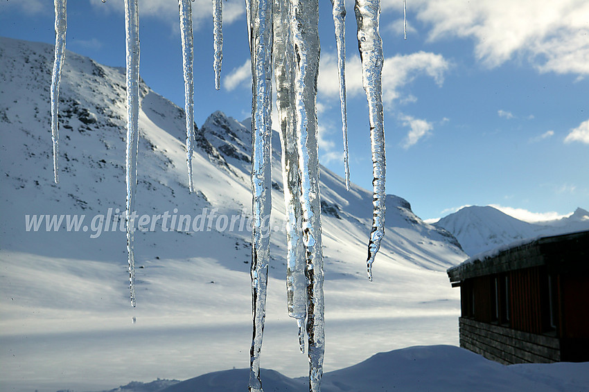 Istapper fra taket på Leirvassbu. Tverrbytthornet (2102 moh) ses i bakgrunnen.