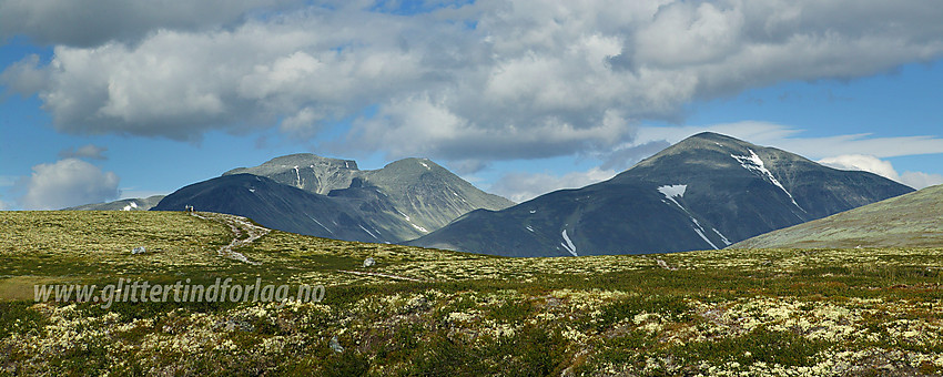 Like ved Spranget parkeringsplass med utsikt nordøstover mot Rondslottet, Vinjeronden og Storronden. På haugen i forgrunnen til venstre ses en liten gruppe fjellvandrere.