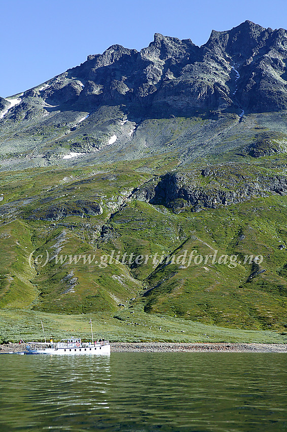 Torfinnstindane sett fra kajakk på Bygdin. Fra venstre mot høyre: Vestre (2085 moh), Midtre (2110 moh) og Øystre (2119 moh). I forgrunnen tøffer m/b Bitihorn østover.