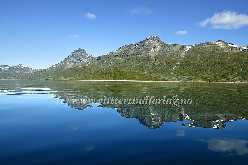 Padling på Bygdin en blikkstille sommerdag. Her er det bl.a. Torfinnstindane (2119 moh) og Nørdre Kalvehølotinden (2019 moh) som speiler seg.