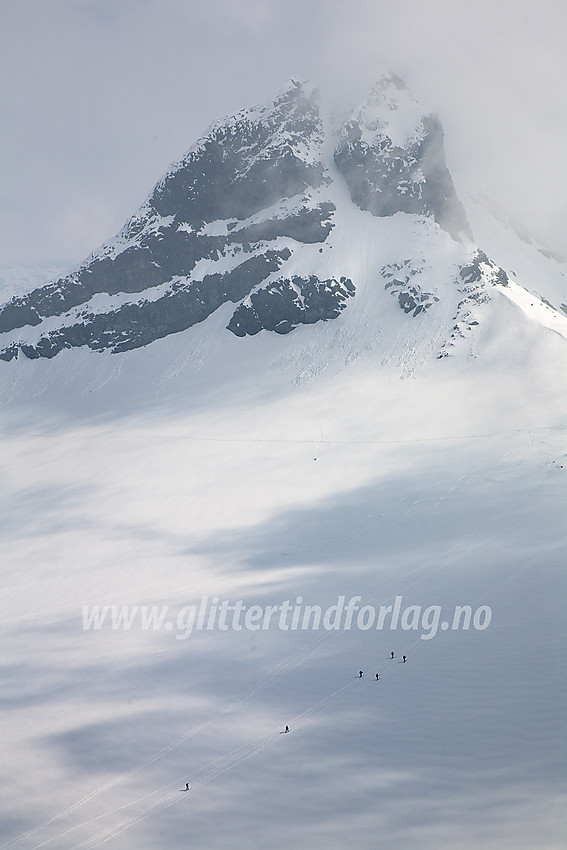 Tallrike skiløpere krysser Leirbrean på vei mot Bjørneskardet. I bakgrunnen ruver Sokse (2189 moh).