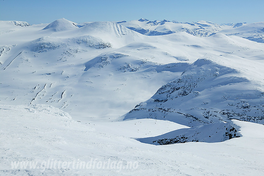 Utsikt sørøstover fra Austre Holåtinden mot Vesldalstinden (1805 moh), Vestraste Hestbreapiggen (2078 moh) og Vestre Hestbreapiggen (2139 moh). I det fjerne ses Jotunheimen.