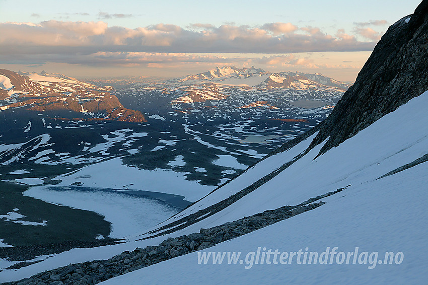 På vei ned sørflanken fra Midtre Hesbtbreapiggen. I bakgrunnen ses bl.a. Sognefjellet og Hurrungane i kveldssol.