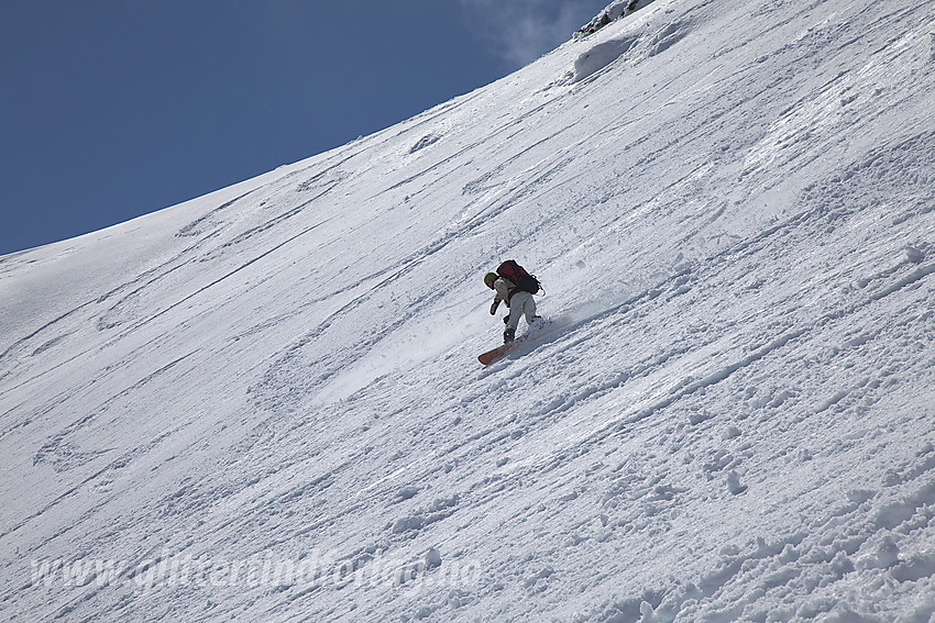 Snowboardkjører på vei ned den bratteste øvre flanken øst for Store Ringstinden.