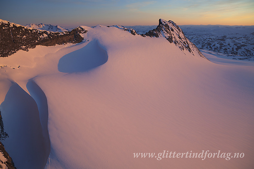 Fra Veslebjørn Nord med utsikt vestover i retning Skeie (2118 moh). I forgrunnen Leirbreans glødende snøflate.