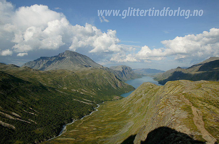 Utsikt fra Memurutunga mot Sjugurdtinden og Memurubu. Til venstre ses Memurudalen med Muru og bak der ruver Besshøe (2258 moh). I det fjerne ses Gjende og Veslfjellet.