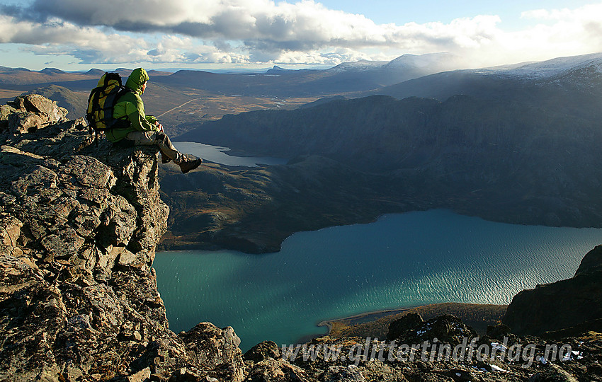 Utsiktspunkt på vei ned fra Veslfjellet mot Gjendesheim. Gjende lyser grønn nedenfor, med Knutshøe bak til høyre i motlyset. Valdresflya ses i bakgrunnen, med Bitihorns kjente silhuett i horisonten.