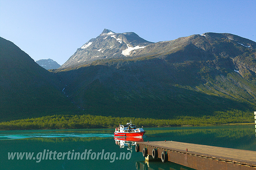 Gjendebåten legger til kai ved Gjendebu med Nørdre Svartdalspiggen (2137 moh) i bakgrunnen.