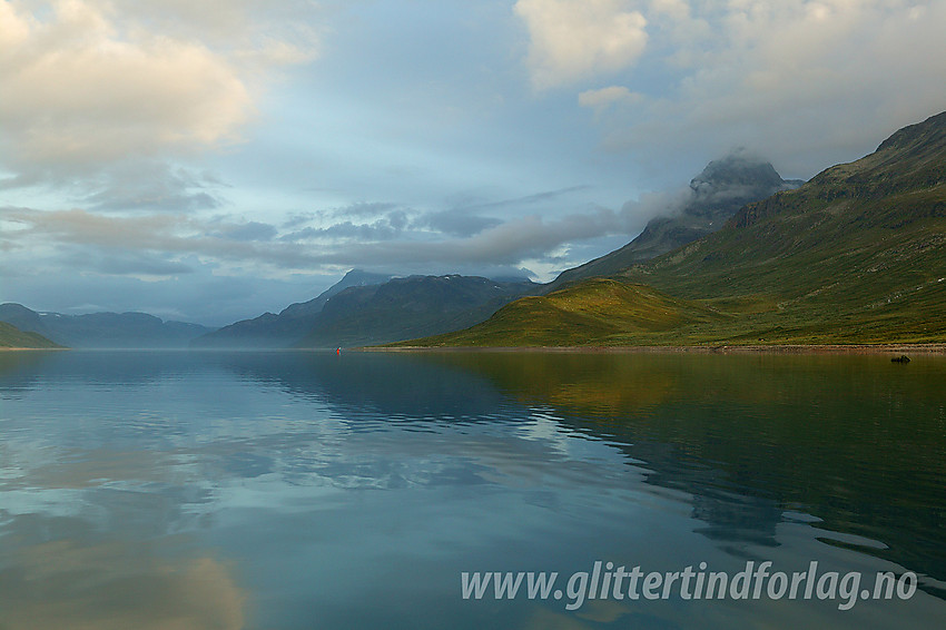 Padling på Bygdin en fredfull sommermorgen. I bakgrunnen duver dovne tåkeskyer rundt toppen på Torfinnstindane (2119 moh).