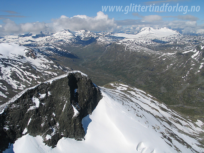 Fra Vestre Rauddalstinden med utsikt i vestlig retning med den vestligste Rauddalstinden (ca. 1930 moh) i forgrunnen. I bakgrunnen strekker Storutledalen seg nedover mot foten av Hurrungane.