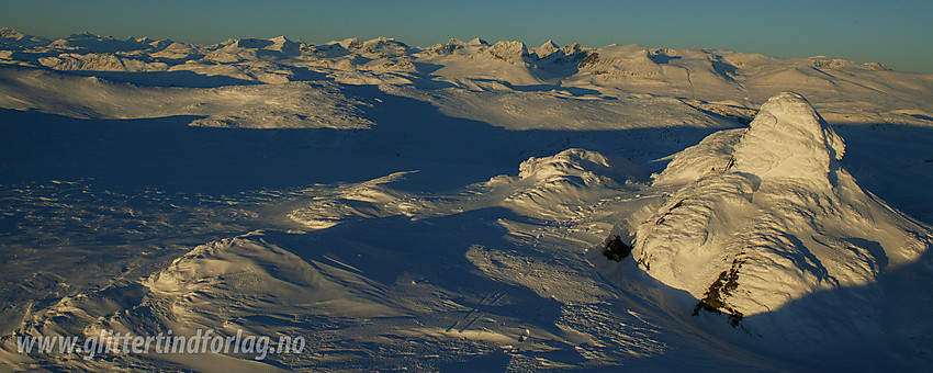 På toppen av Mugnetinden (1737 moh) med utsikt nordover-nordvestover mot Jotunheimens tinderekker.