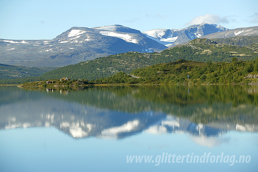 Ved Øvre Sjodalsvatnet en blikkstille sommermorgen. I bakgrunnen bl.a. Rasletinden og Munken.