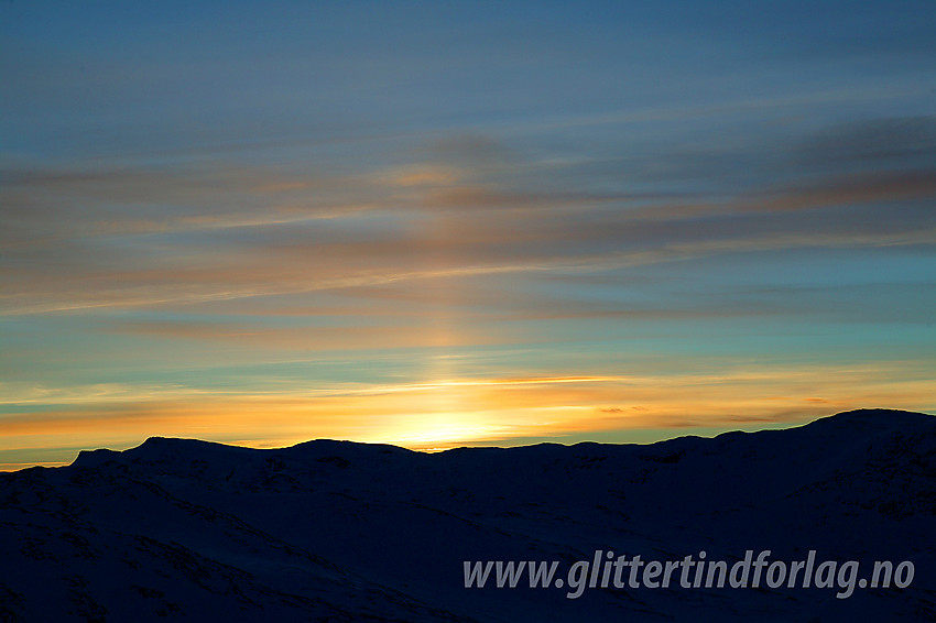 På Bitihorns nordvestrygg en vinterkveldm mot Mugnetinden og Skyrifjellet/Svarteknippa.