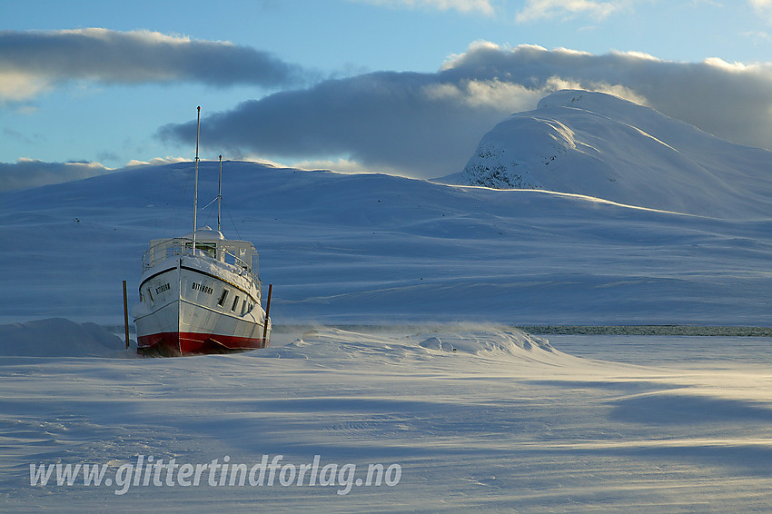 M/b Bitihorn i vinteropplag på Fagerstrand med toppen Bitihorn (1607 moh) i bakgrunnen.