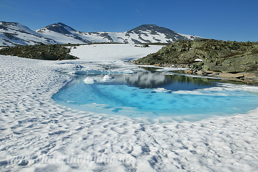 I Breidalen ved et idyllisk isvann med Holåtindane i bakgrunnen.