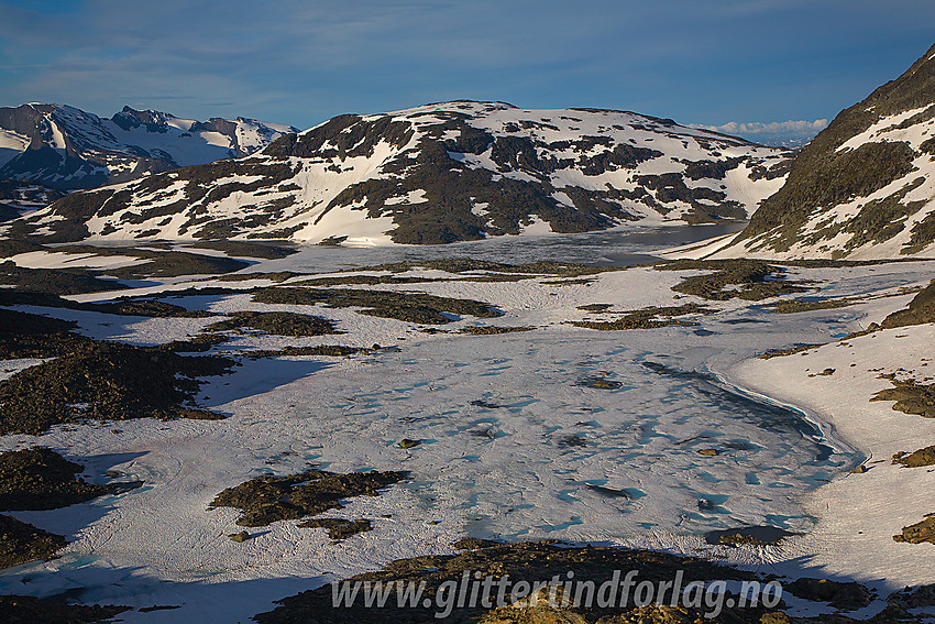 Islagt tjern på 1692 moh like ved Vestre Memurubrean med Storådalshøe (1888 moh) i bakgrunnen.