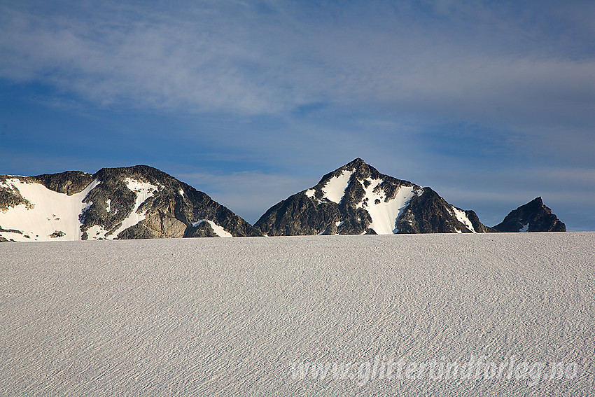 I kanten av Vestre Memurubrean med Nestsøre (2255 moh), Store (2346 moh) og Midtre (2339 moh) Hellstugutinden i bakgrunnen.