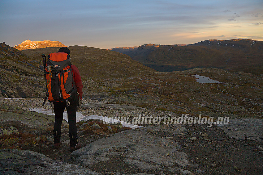 På stien fra Mjølkedalsvatnet ned mot Eidsbugarden en høstkveld. Dagen er på hell og solstrålene gjør et siste sveip over Galdebergtinden, Hundeknappen og Skjenegge.