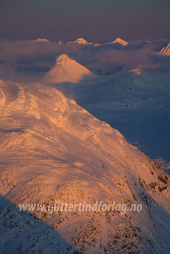 Fra Gravdalstinden mot Surtningstinden og Kyrkja. I bakgrunnen over tåkeskyene ses Hellstugutindane.