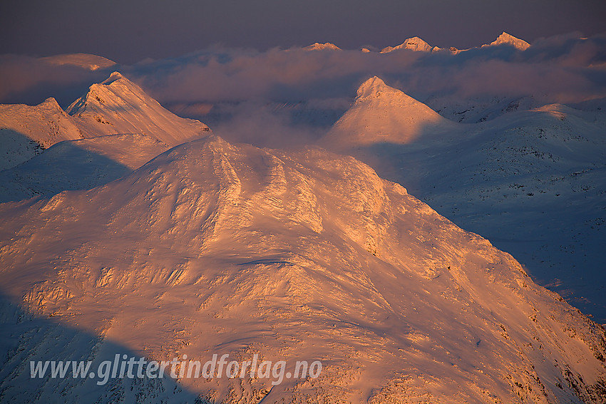 Fra Gravdalstinden mot Surtningstinden (1997 moh), Tverrbytthornet (2102 moh) og Kyrkja (2032 moh) ved solnedgang. I bakgrunnen ses Hellstugutindane.