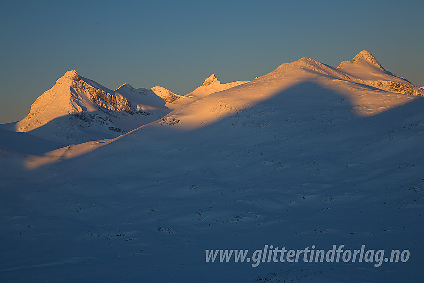 Under oppstigning mot Høgvaglbreen fra nord med utsikt til Smørstabbtindane i soloppgang. Storebjørn (2222 moh) bak til venstre og Stetinden (2020 moh) litt mer foran til høyre.