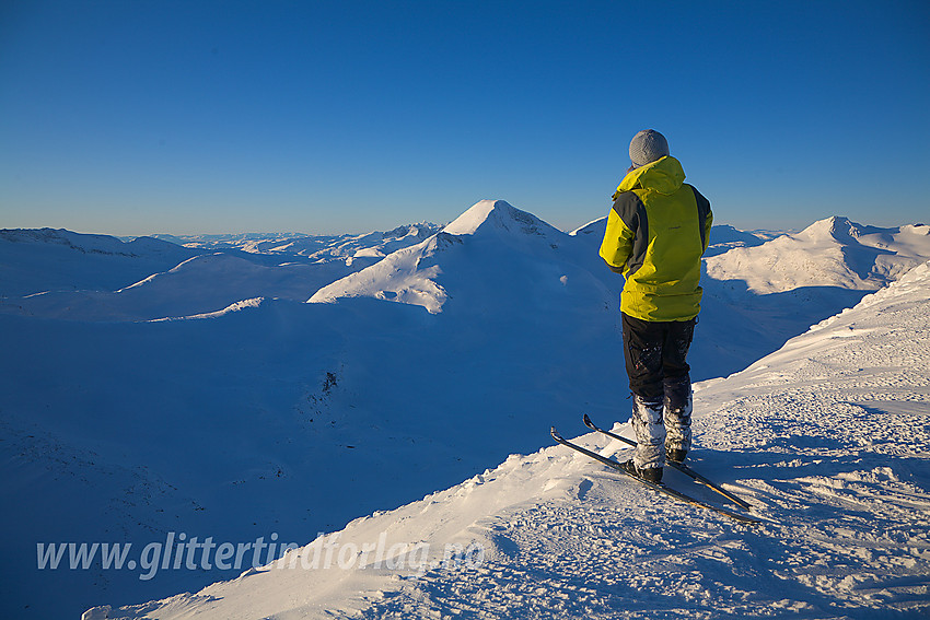 På skulderen like sør for Midtre Høgvagltinden med utsikt bort til Store Rauddalstinden (2157 moh). I det fjerne skimtes litt av Hurrungane. Bak til høyre ses Gravdalstinden mens litt av Sagi ses bak til venstre.