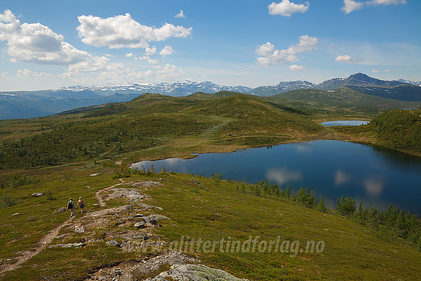 Fjellvandrere på vei ned fra Melbysfjellet. Til høyre ses Tutjednet. Helt i bakgrunnen bl.a. Mugnetinden og Bitihorn.