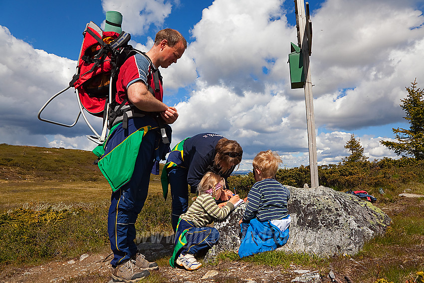 Signering av toppbok som ligger i postkasse mellom de to toppene på Goarenfjellet i Etnedal.