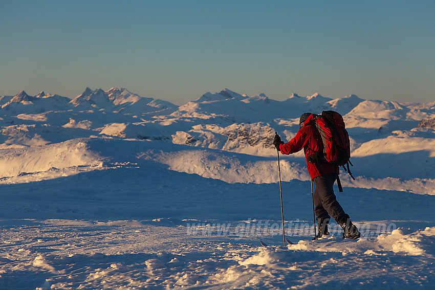 Skiløper på toppen av Mugnetinden (1737 moh) i Vang. Vestlige deler av Jotunheimen ses i bakgrunnen.