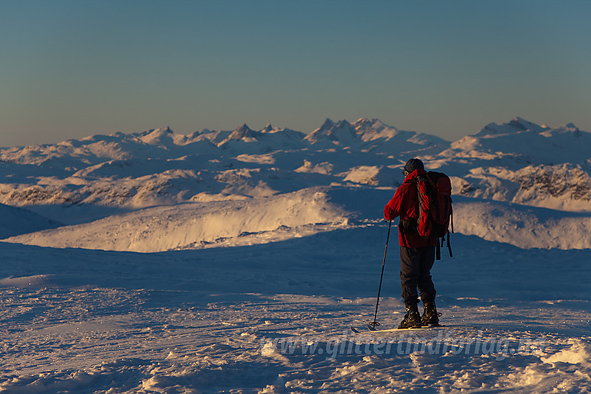 Skiløper på toppen av Mugnetinden (1737 moh) i Vang. Vestlige deler av Jotunheimen ses i bakgrunnen.