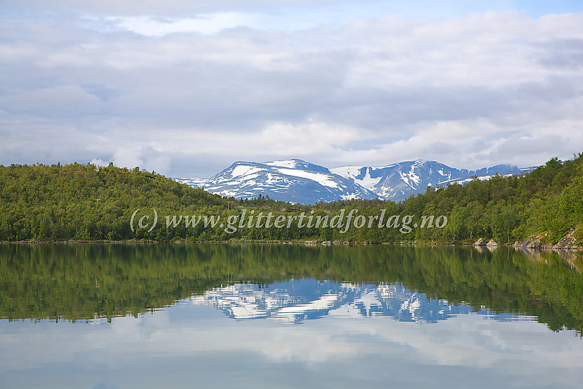 Sommer med kajakk på Øvre Sjodalsvatnet mot Rasletinden, Mugna og Munken som speiler seg i vannet.