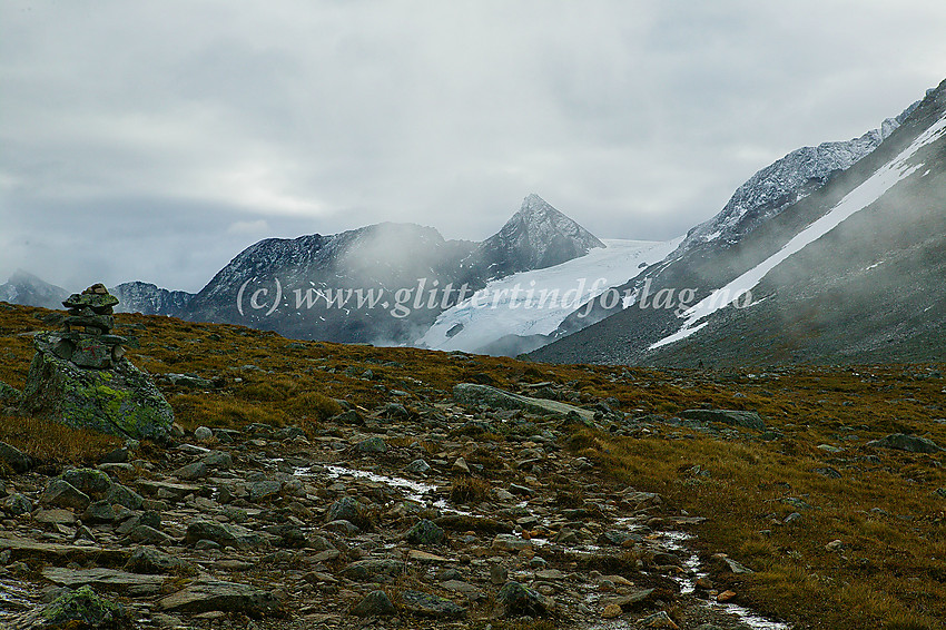 På vei gjennom Kyrkjeglupen langs stien mellom Leirvassbu og Spiterstulen. I bakgrunnen ses bl.a. Urdadalstinden (2116 moh.), Semelholstinden (2147 moh.) og Visbrean.