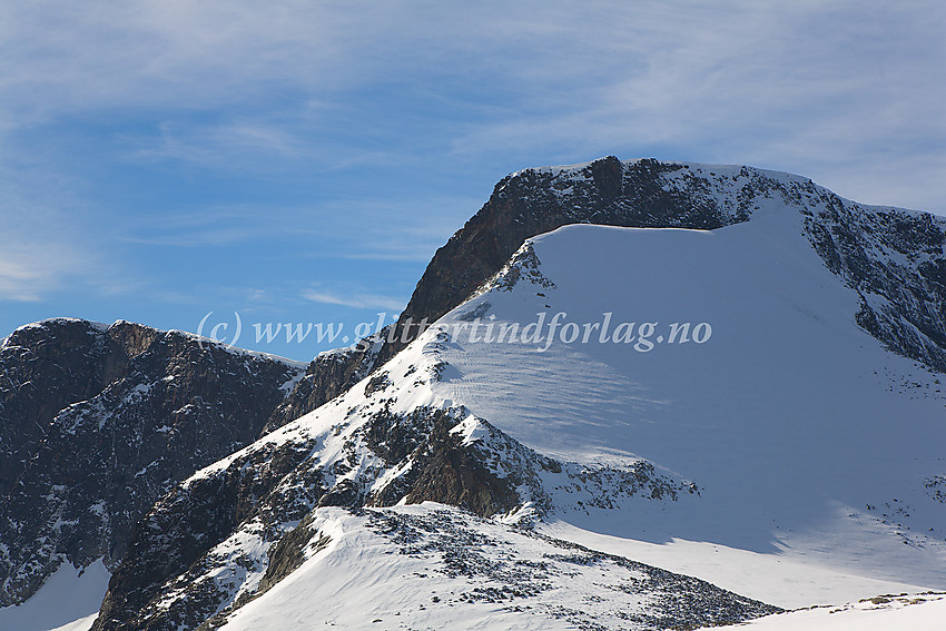 Midtre Tverrbottinden Nord (2151 moh.) med den karakteristiske snøkammen som fører opp til toppen fra øst. I bakgrunnen til venstre ses Midtre Tverrbottinden Sør (2106 moh.)