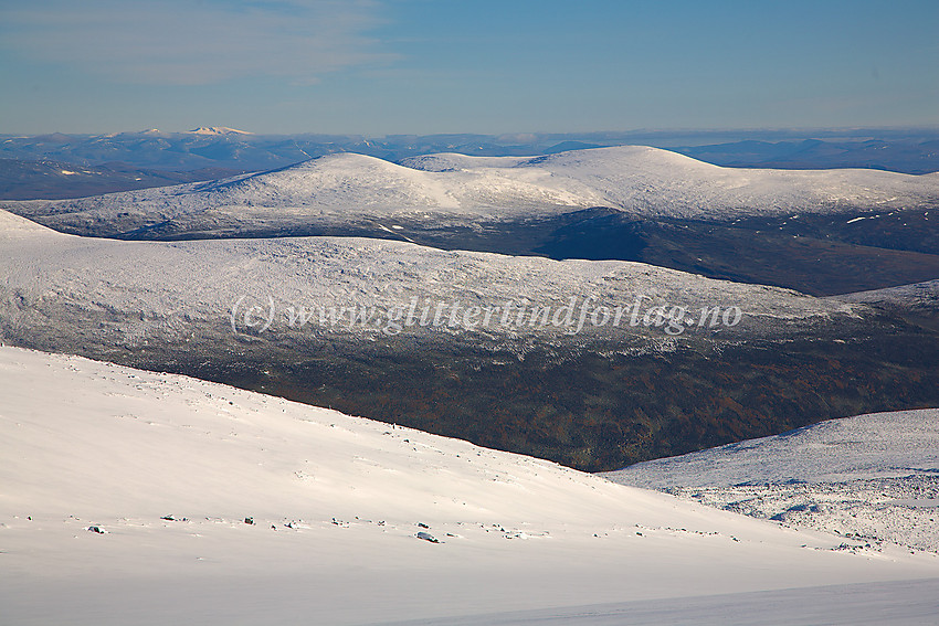 Utsikt fra Gråsubrean nord til nordøstover mot Kvitingskjølen (2064 moh.) med sine tre topper over 2000 moh.  I det fjerne kvitner Dovrefjells stortopper mot himmelranden.